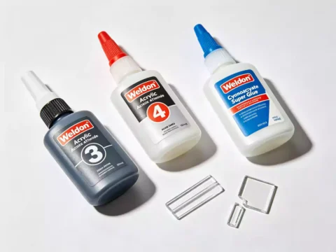 Weldon acrylic adhesives and cyanoacrylate glue bottles with bonded acrylic samples