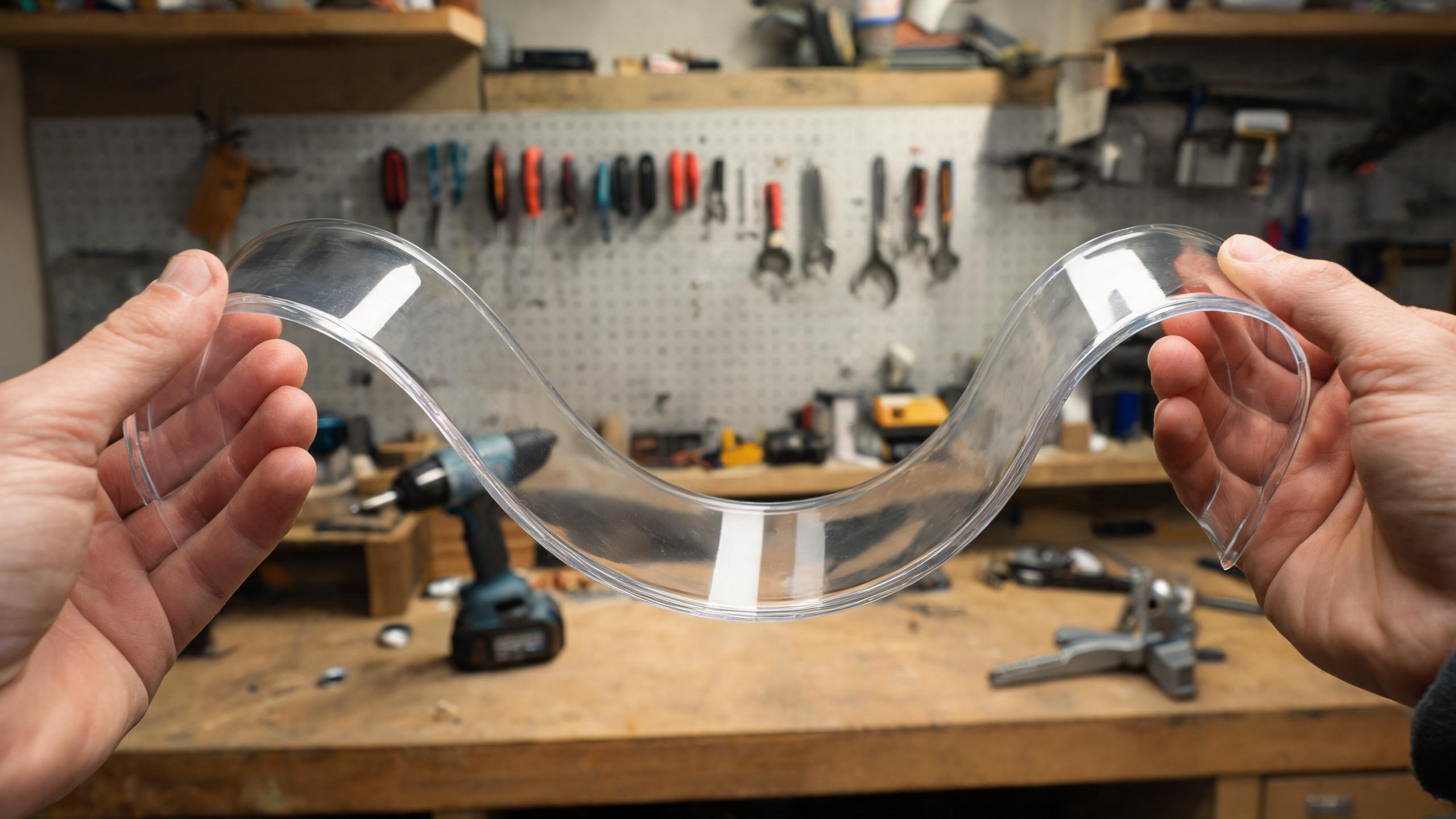 Flexible polycarbonate sheet being bent to show impact resistance